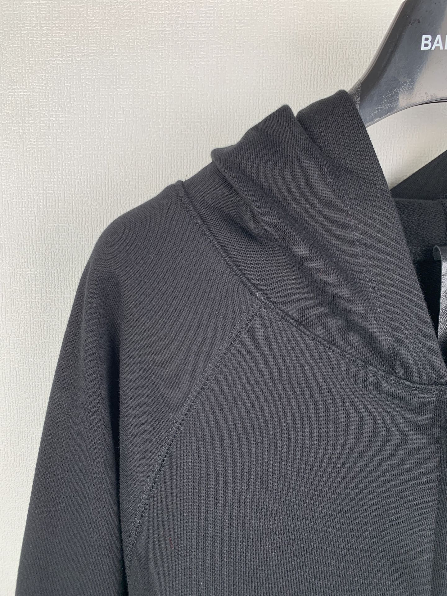 Black zip-up hoodie shoulder and hood seam details