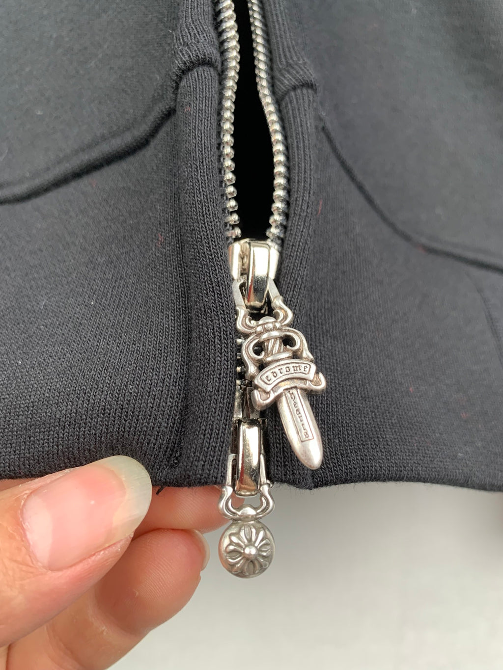 Dark gray zip hoodie with chrome-tone charm zipper pull and tassel detail