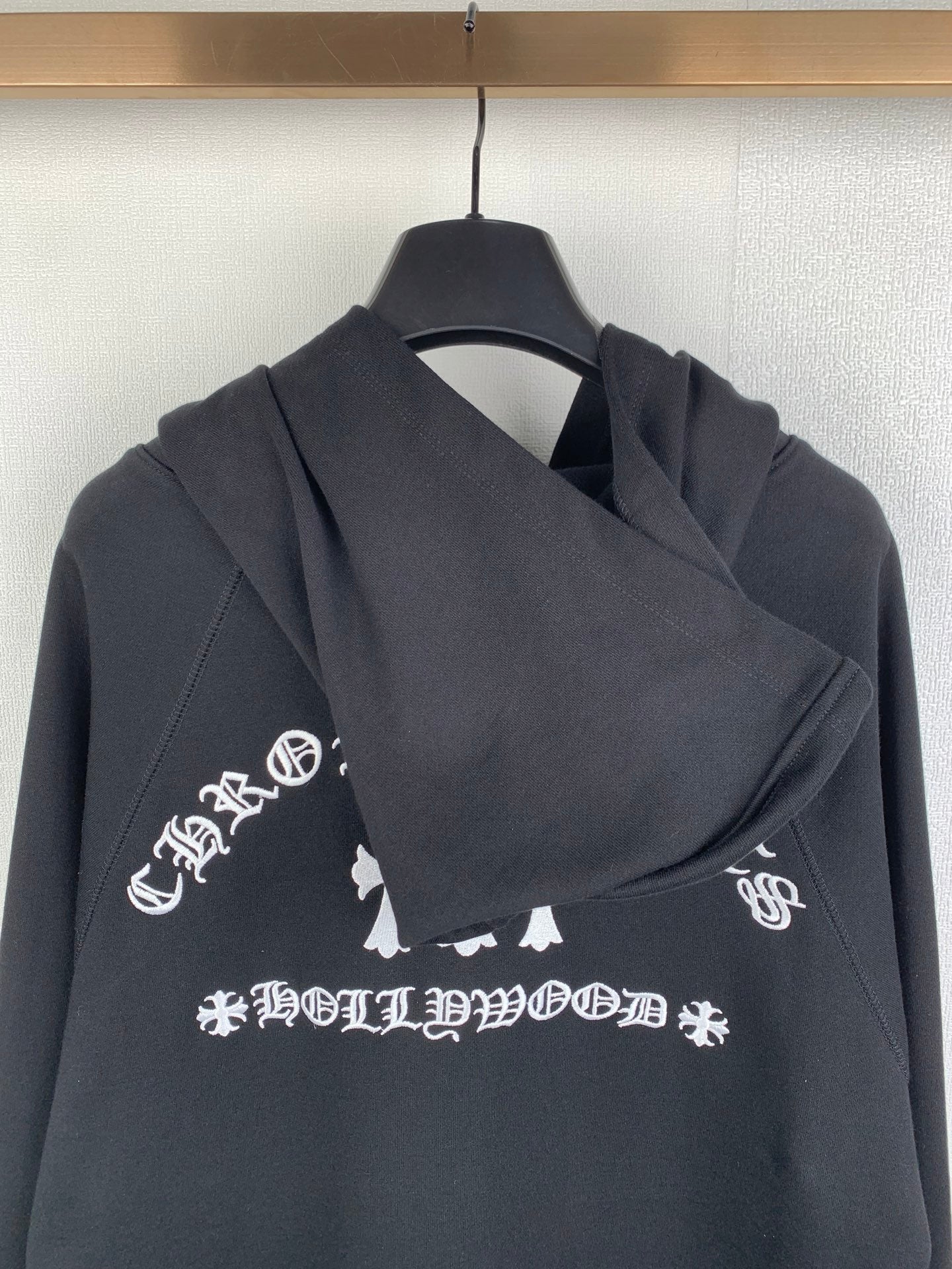 Black zip-up hoodie with hood and white logo graphic on chest