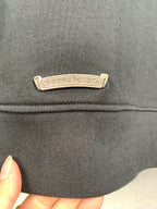 Dark gray hoodie chest logo label in chrome-tone metal