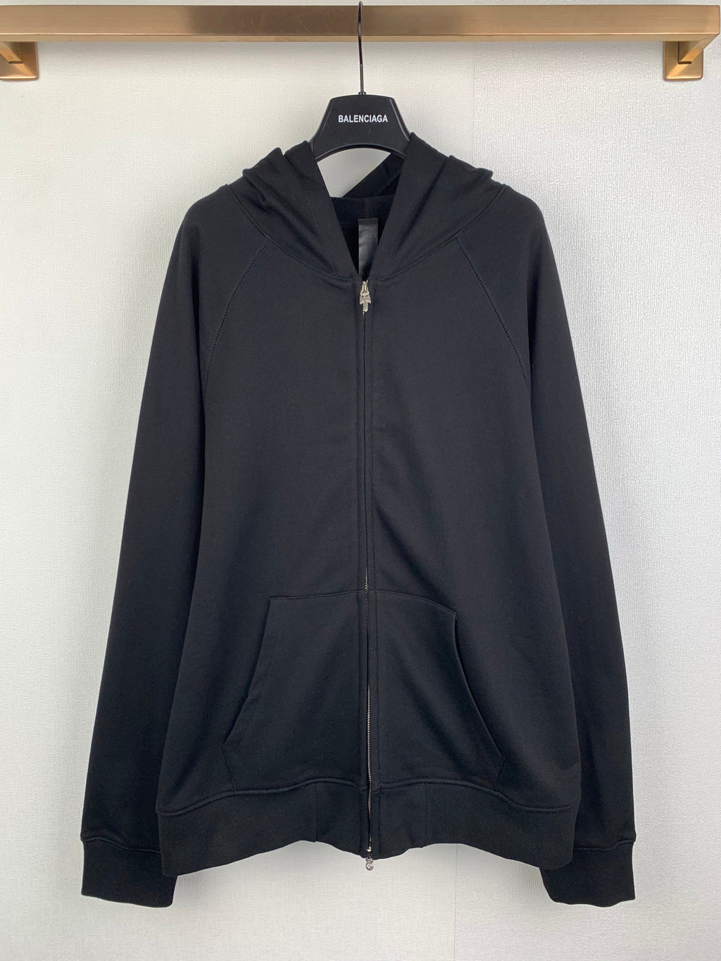 Black zip-up hoodie with hood, front pocket, and metal zipper