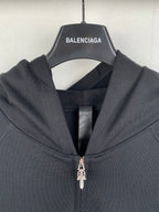 Black zip-up hoodie close-up with metal zipper pull and hood lining