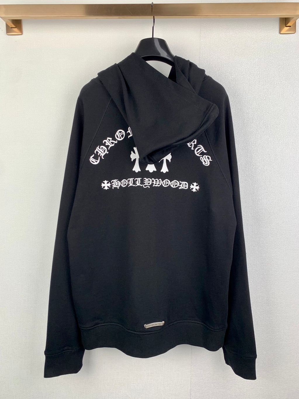 Black zip-up hoodie with hood, white graphic text, and full-length zipper