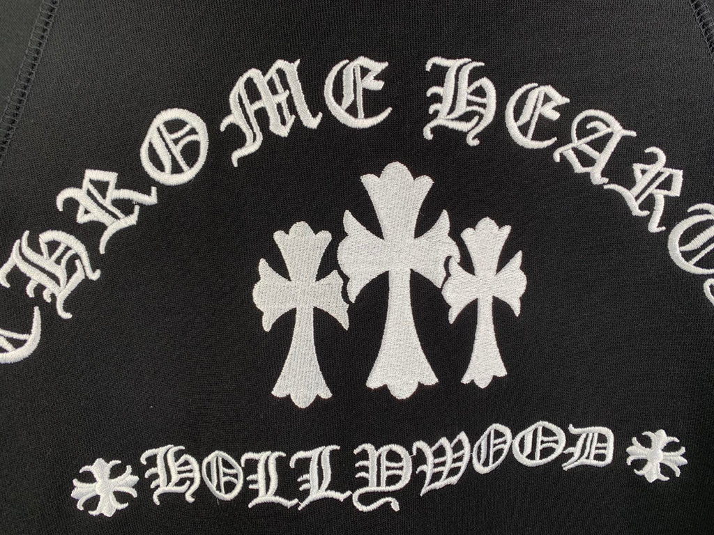 Black hoodie front graphic with white decorative lettering and cross flower emblem