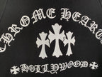 Black hoodie front graphic with white decorative lettering and cross flower emblem