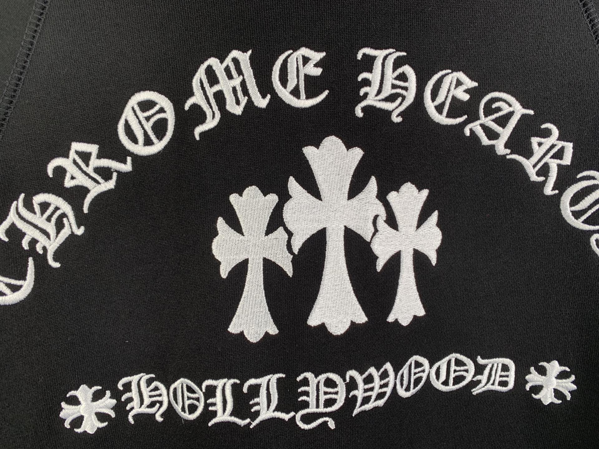 Black hoodie front graphic with white decorative lettering and cross flower emblem
