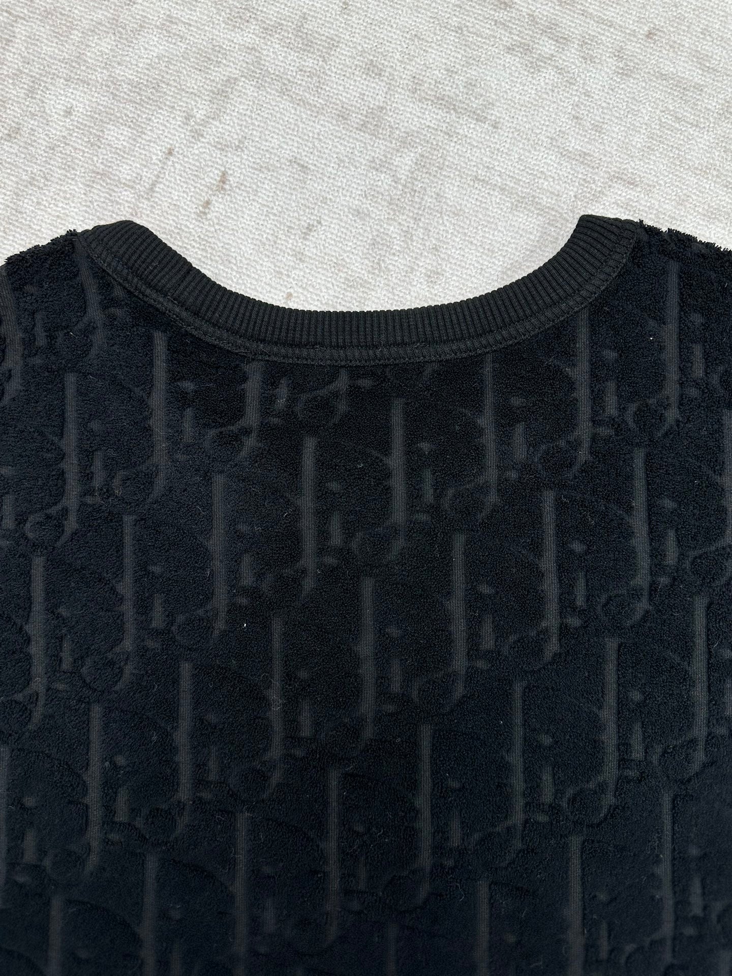 Black Dior crew-neck T-shirt front close-up, textured logo
