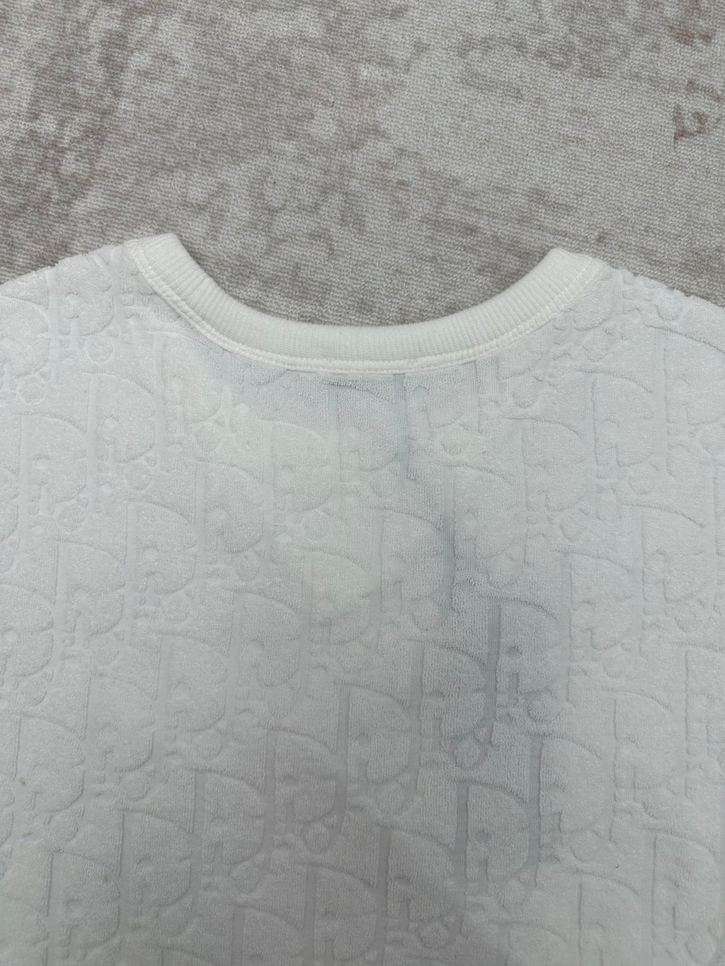 White crewneck T-shirt neckline with ribbed collar and embossed fabric texture