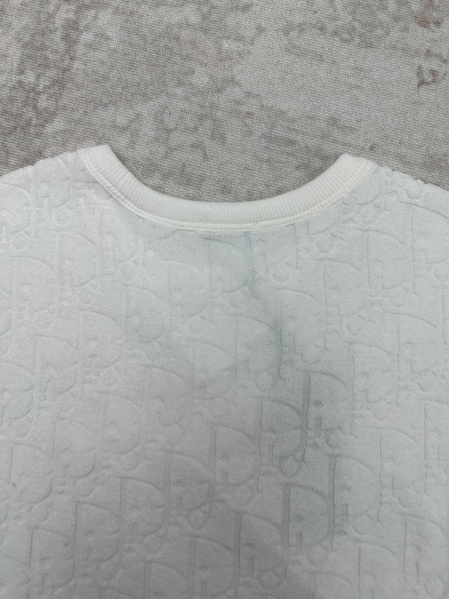 White crewneck T-shirt neckline with ribbed collar and embossed fabric texture