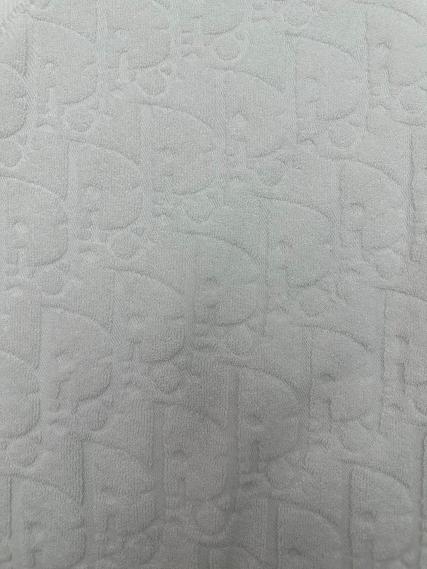 White embossed textured fabric on a short-sleeve crewneck T-shirt
