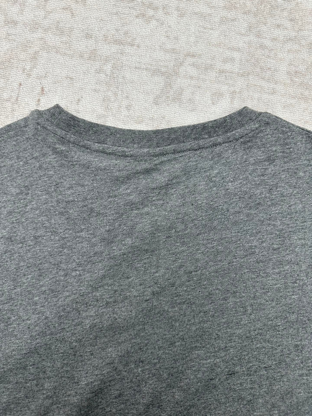 Grey crew-neck T-shirt collar and upper chest area, no visible graphic