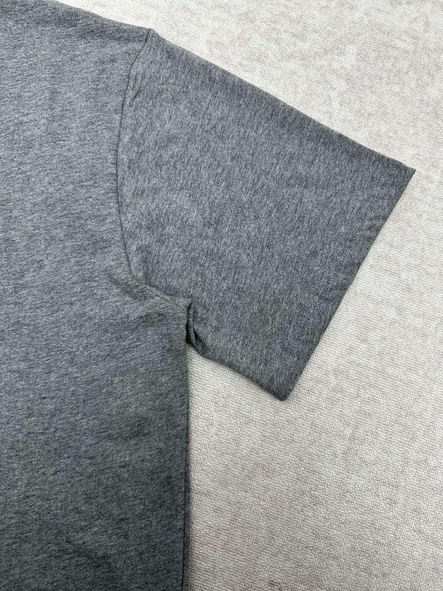 Grey T-shirt sleeve and side seam close-up