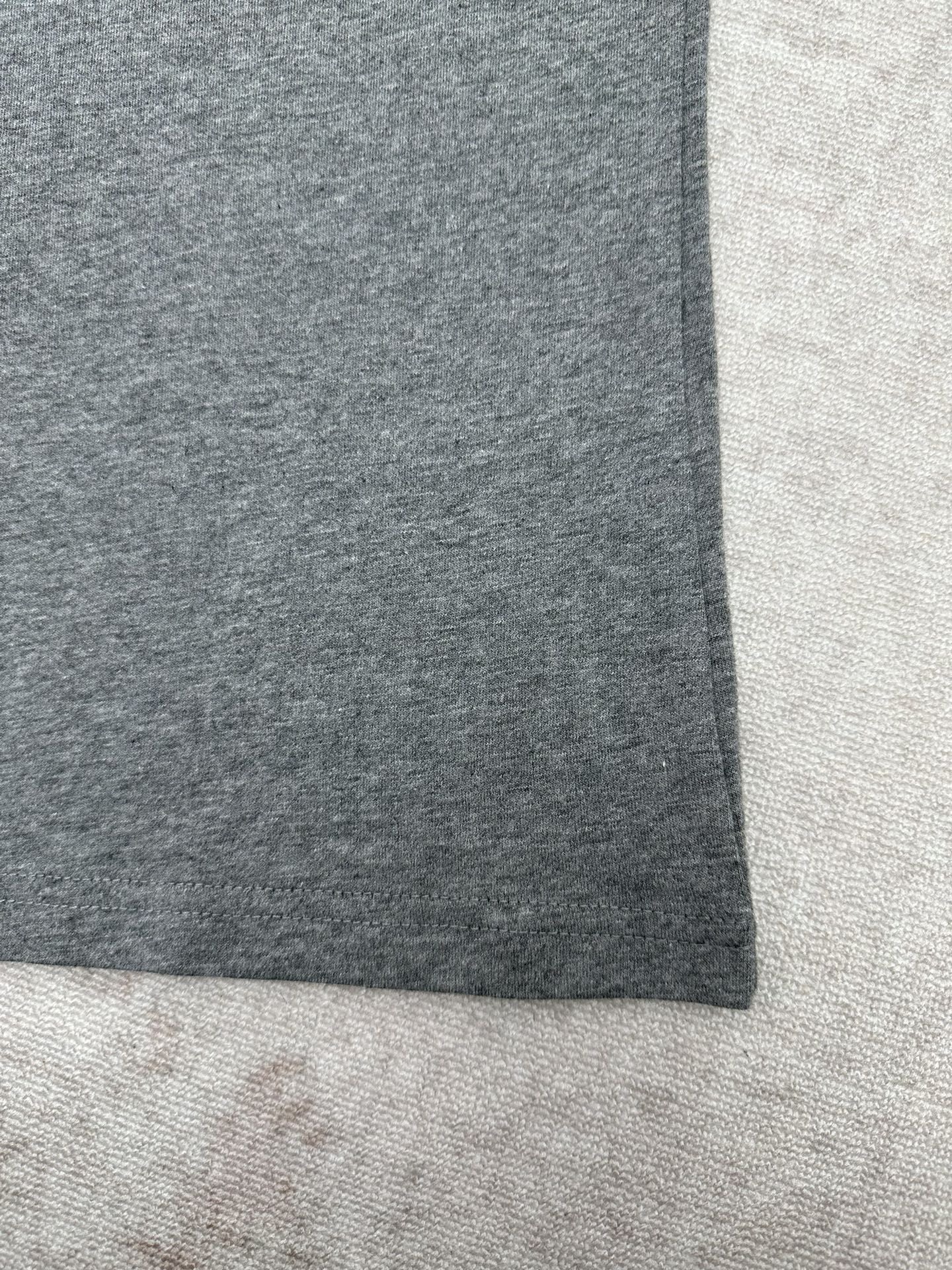 Grey short-sleeve T-shirt hem close-up, straight side seam