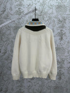 Cream knit cardigan neckline with black, blue, and tan striped rib trim