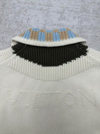 Cream knit cardigan collar with blue-and-tan check stripe and black band