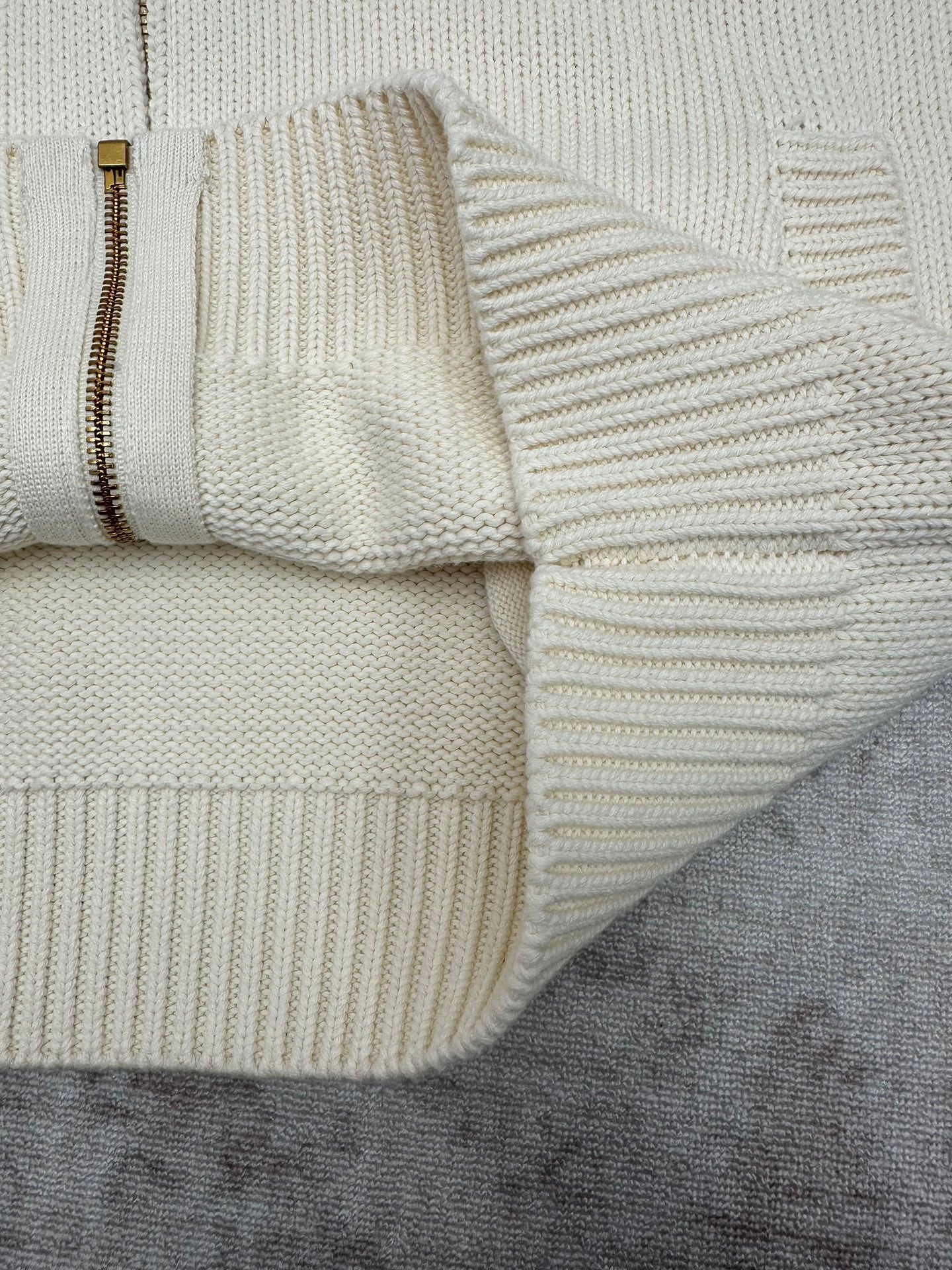 Cream knit cardigan hem with zipper edge and ribbed knit detail