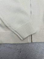 Cream knit cardigan cuff and zipper placket close-up