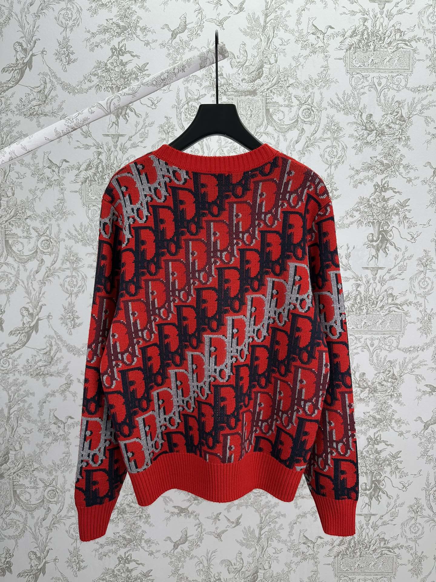 Dior knit sweater in red and dark blue with repeating logo pattern, ribbed hem