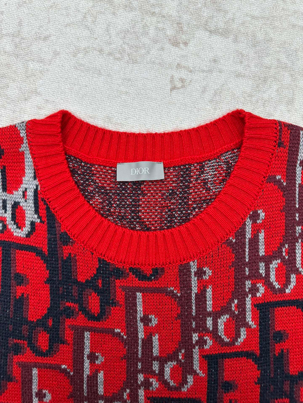 Dior knit sweater neckline with red ribbed trim and dark blue patterned yoke