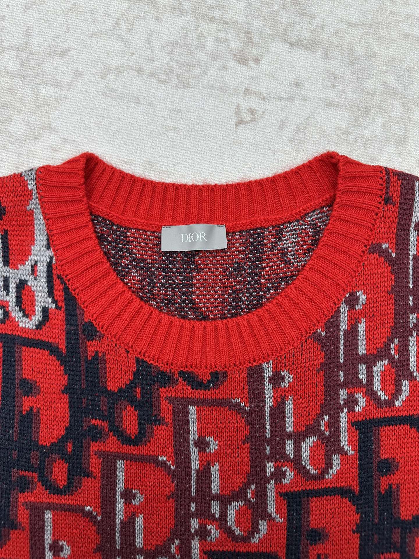 Dior knit sweater neckline with red ribbed trim and dark blue patterned yoke