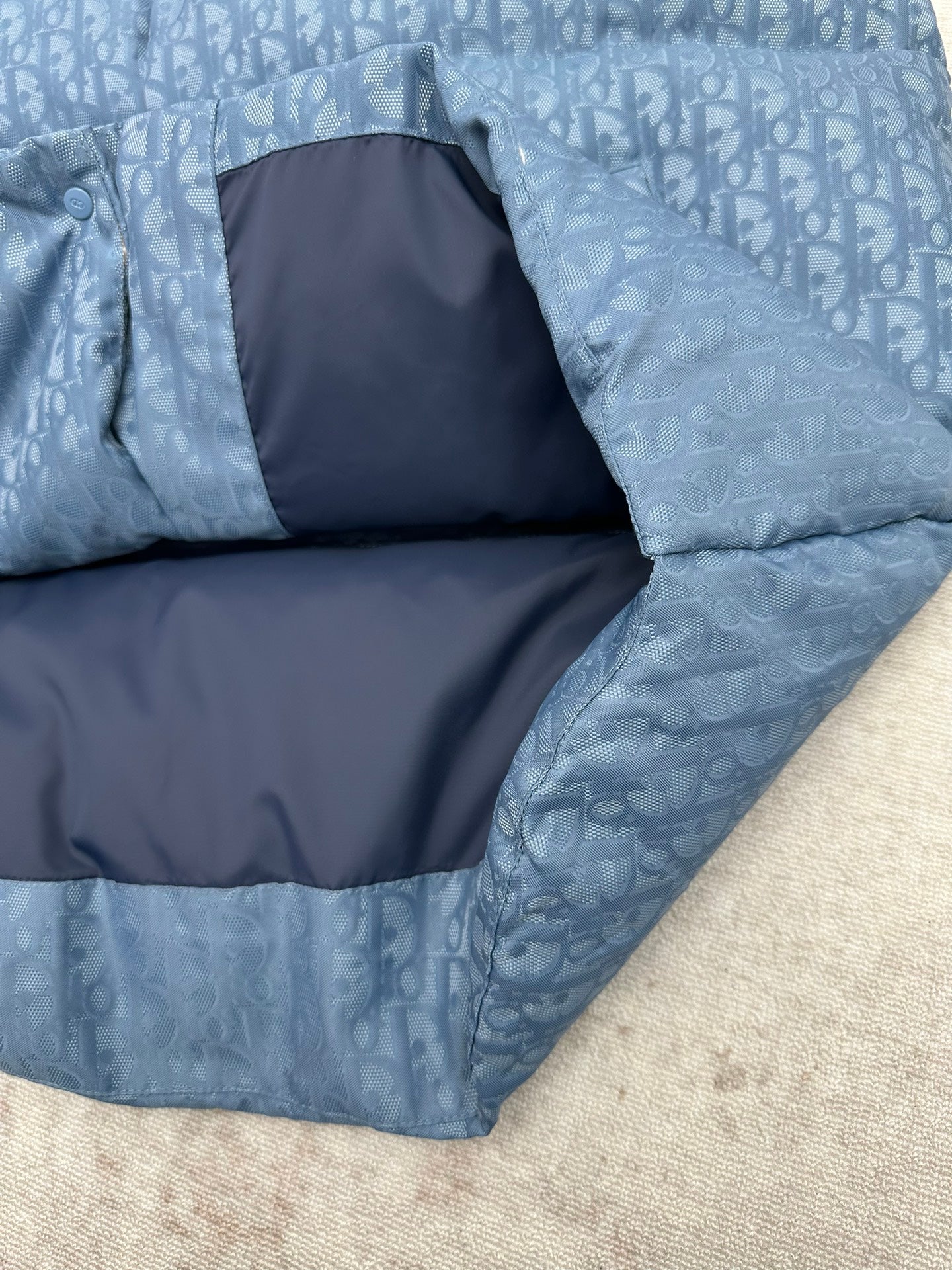 Blue Dior monogram puffer vest interior lining and quilted panels, folded corner view.