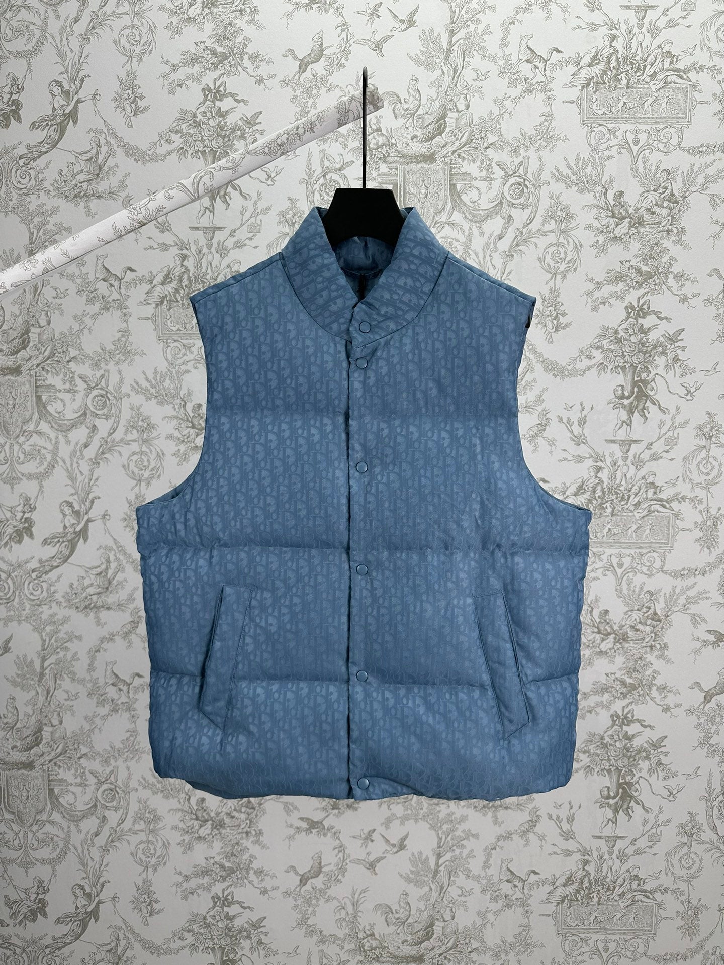 Blue Dior monogram puffer vest, sleeveless with stand collar and snap front.