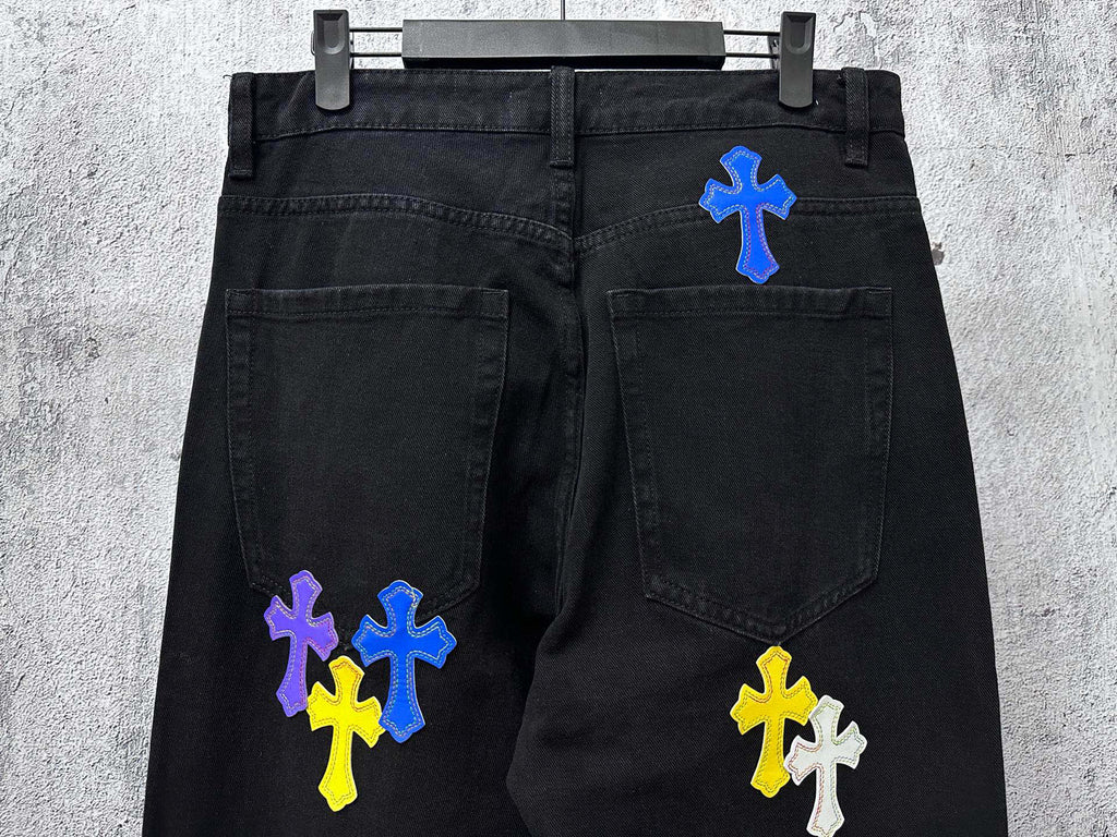 Black denim pants with blue, yellow, and purple cross patches on front