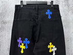 Black denim pants with blue, yellow, and purple cross patches on front