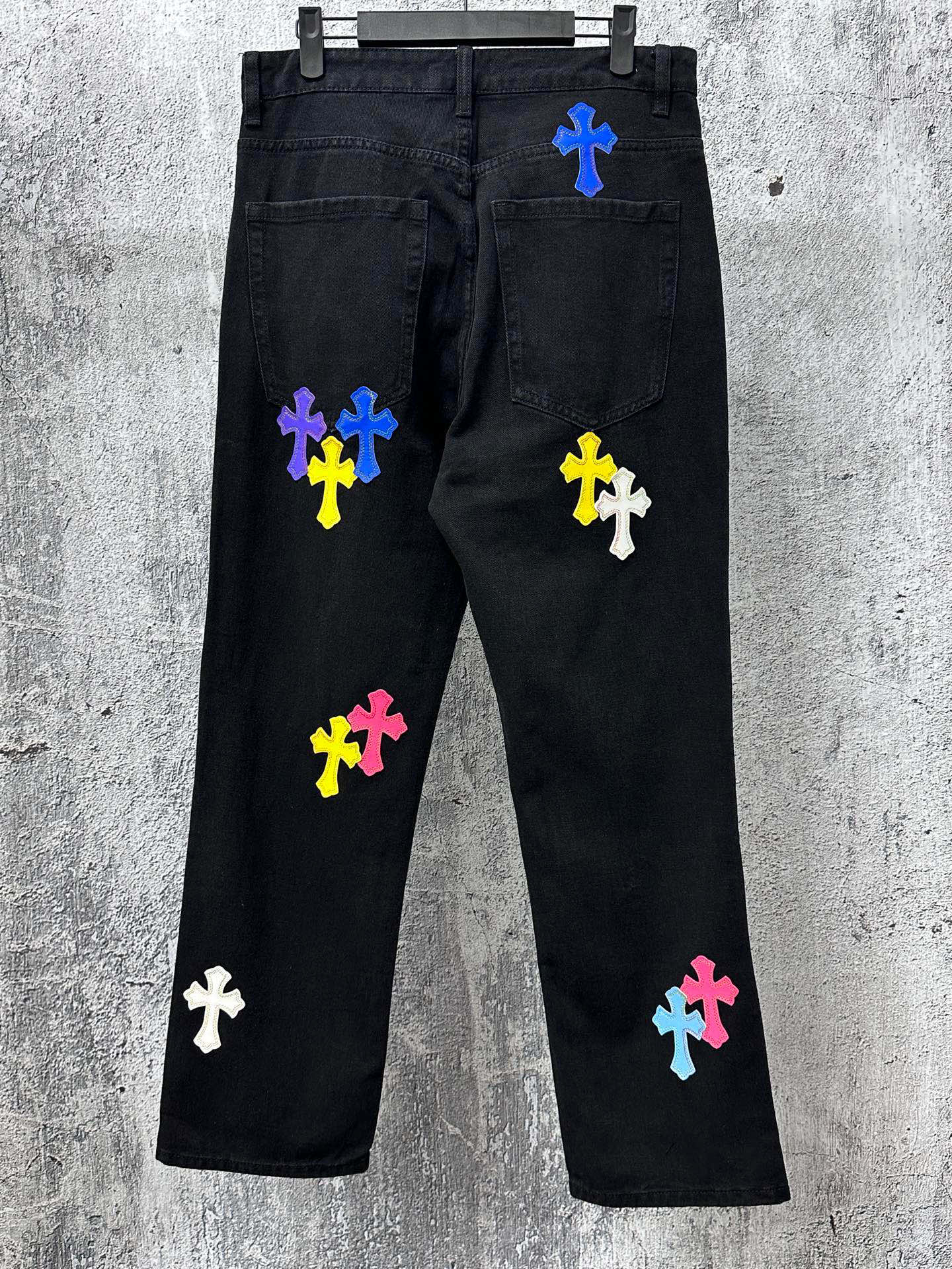 Black denim pants with multicolor cross patches on legs and back pockets