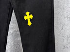 Black denim pants with yellow cross patch on upper thigh