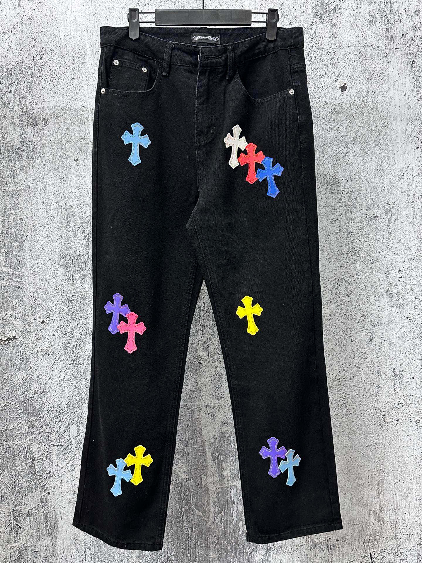 Black denim pants with multicolor cross patches, straight leg
