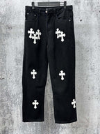 Chrome pants in dark denim with white cross and clover-style patches, front view