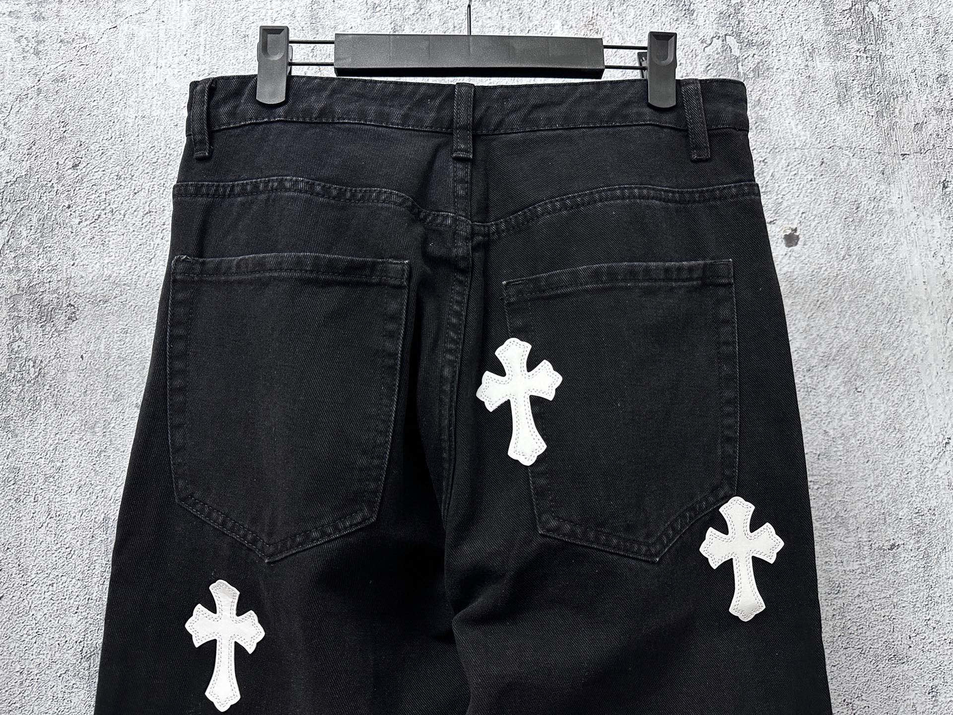 Dark denim pants with white cross patches on legs and side pockets