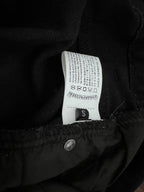 Dark denim pants inner waistband label with size S and care symbols