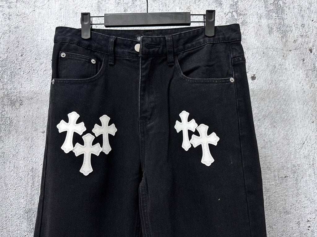 Dark denim pants with two white cross patches on front, button fly