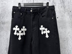 Dark denim pants with two white cross patches on front, button fly