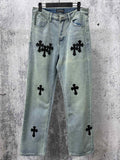 Light blue denim pants with black cross patches, button fly