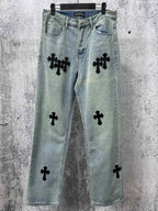 Light blue denim pants with black cross patches, button fly