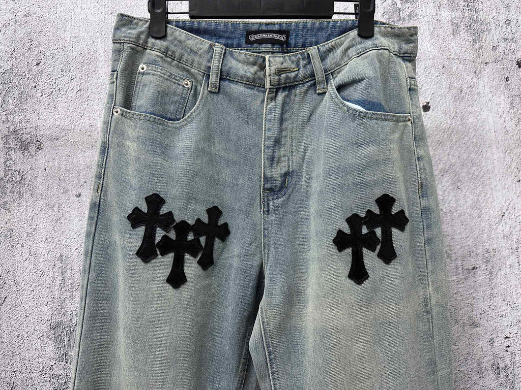 Light blue denim pants with black cross patches on both legs