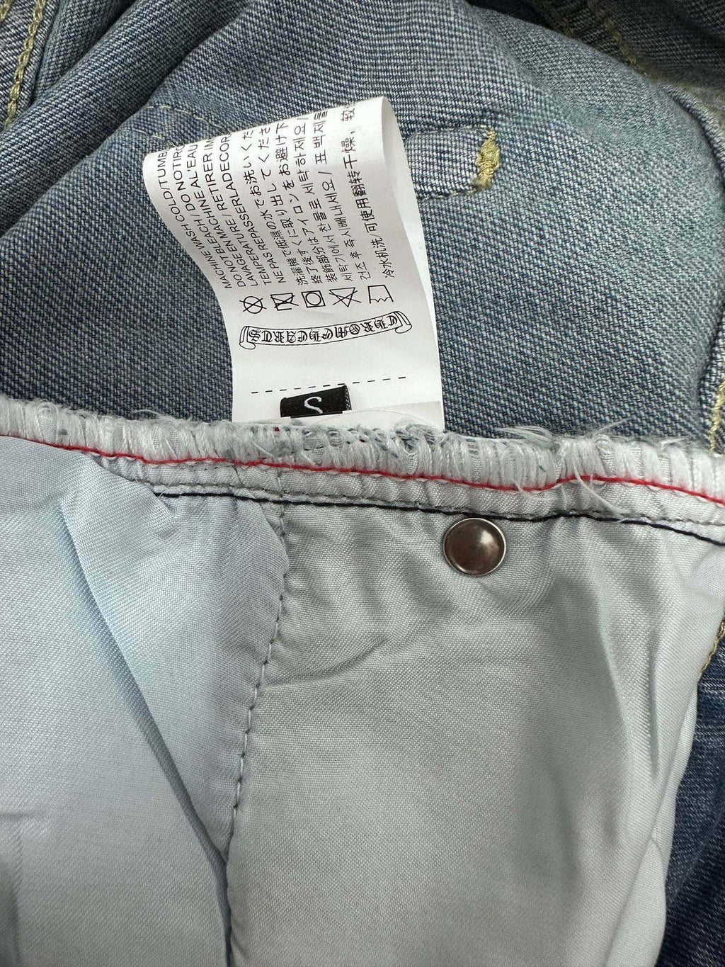 Light-wash denim pants tag and button at waistband, size S