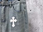Light-wash denim waistband with belt loops and a large white cross patch