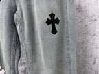 Light-wash denim leg with a black cross patch