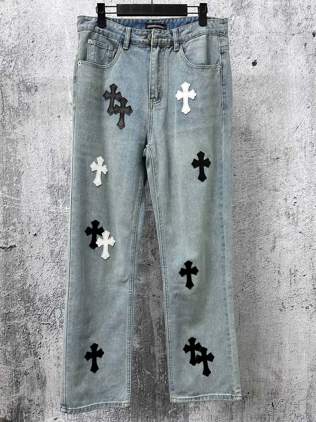 Light-wash denim pants with black and white cross patches