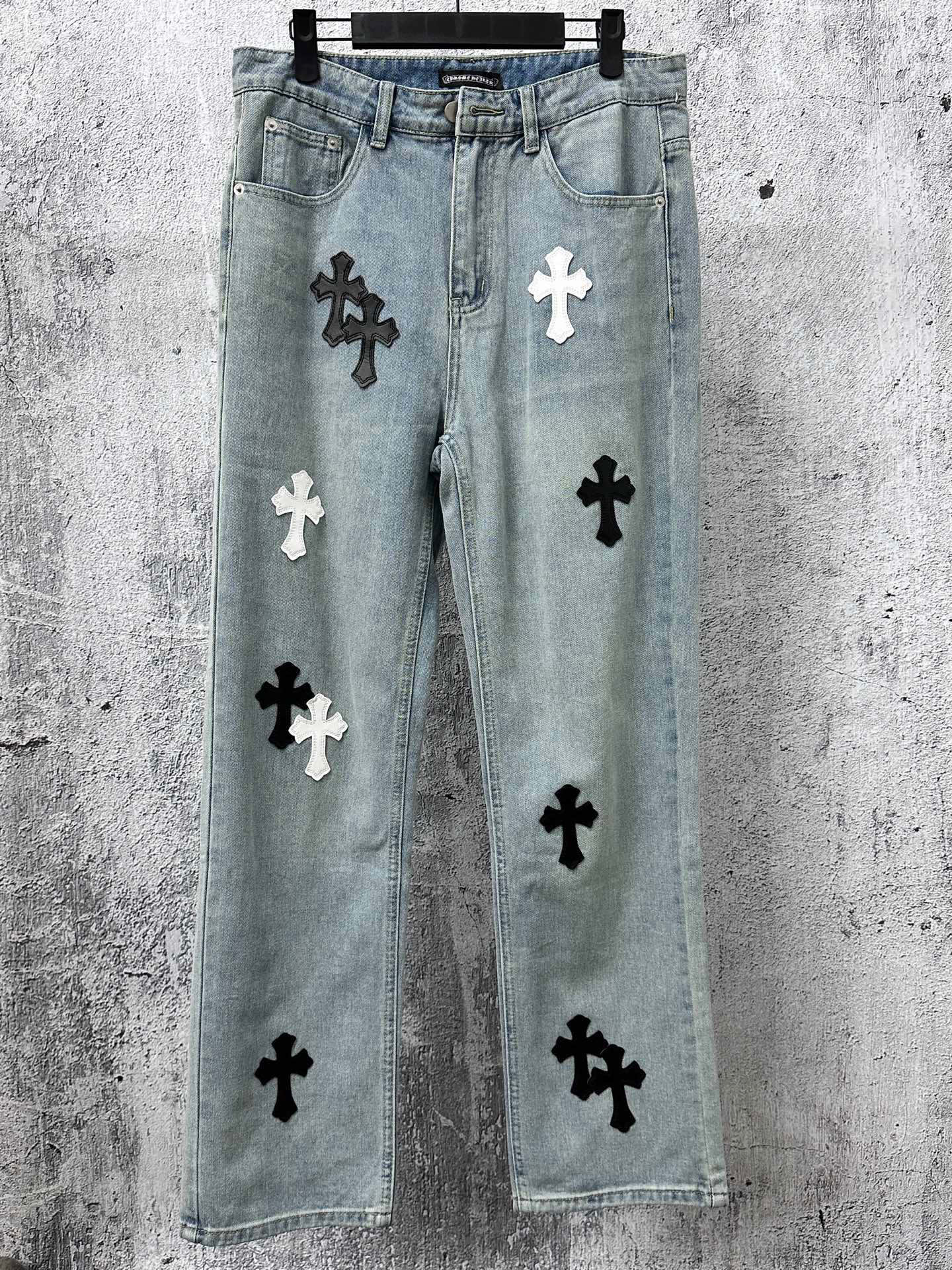 Light-wash denim pants with black and white cross patches