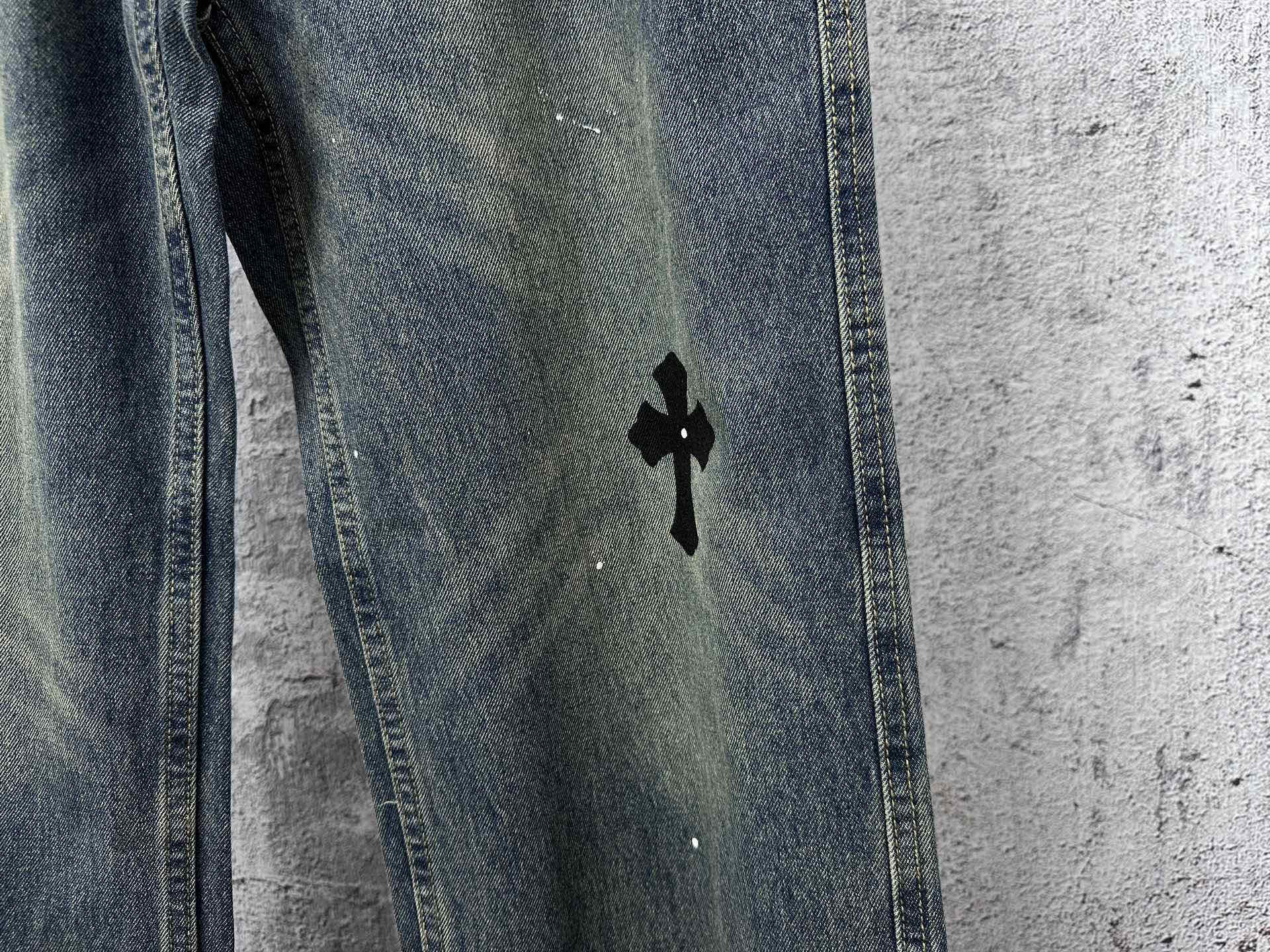 Blue denim jeans pants with a black cross graphic on the thigh