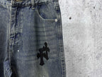 Blue denim jeans with black cross graphic near the front pocket