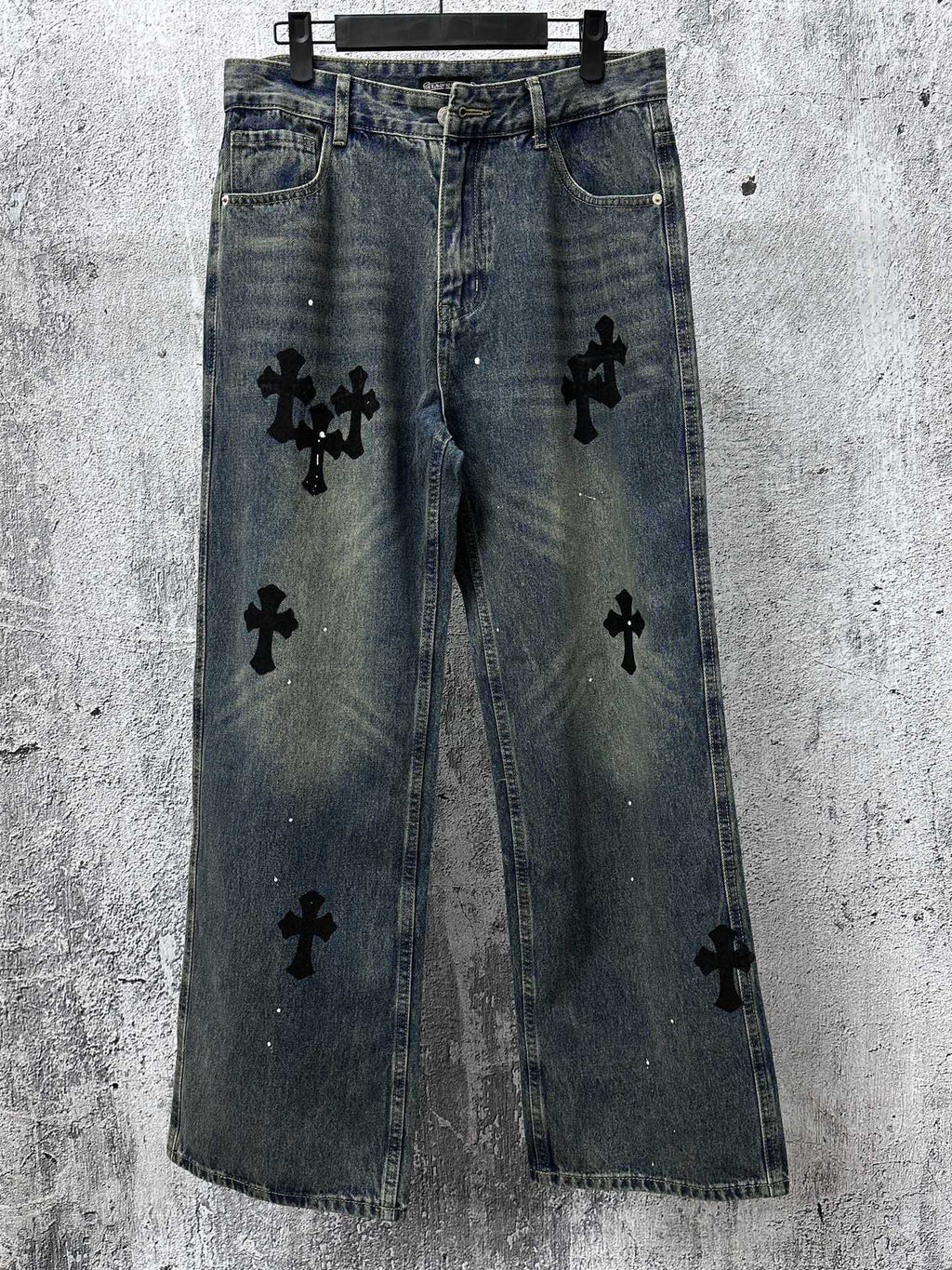 Blue denim jeans pants with black cross-like graphic patches on the legs