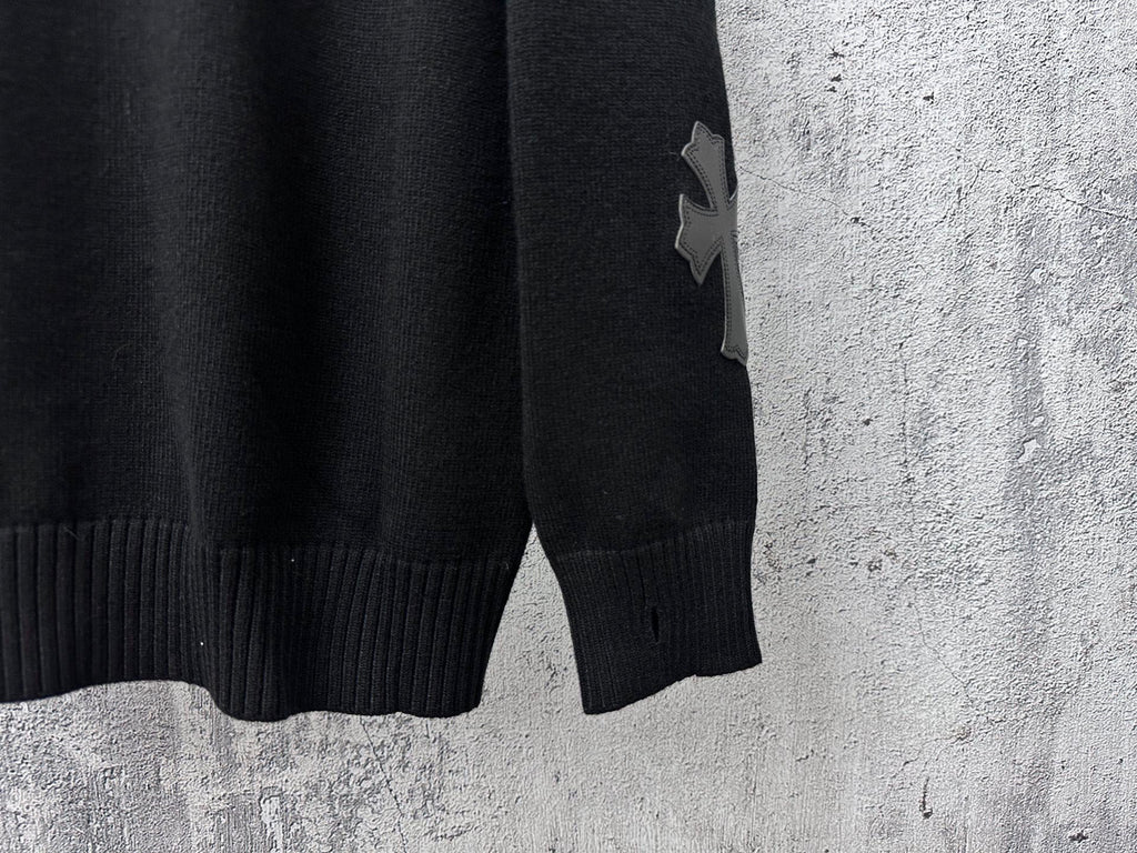 Black knit sweater with ribbed hem and star applique on sleeve