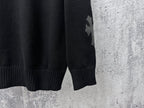 Black knit sweater with ribbed hem and star applique on sleeve