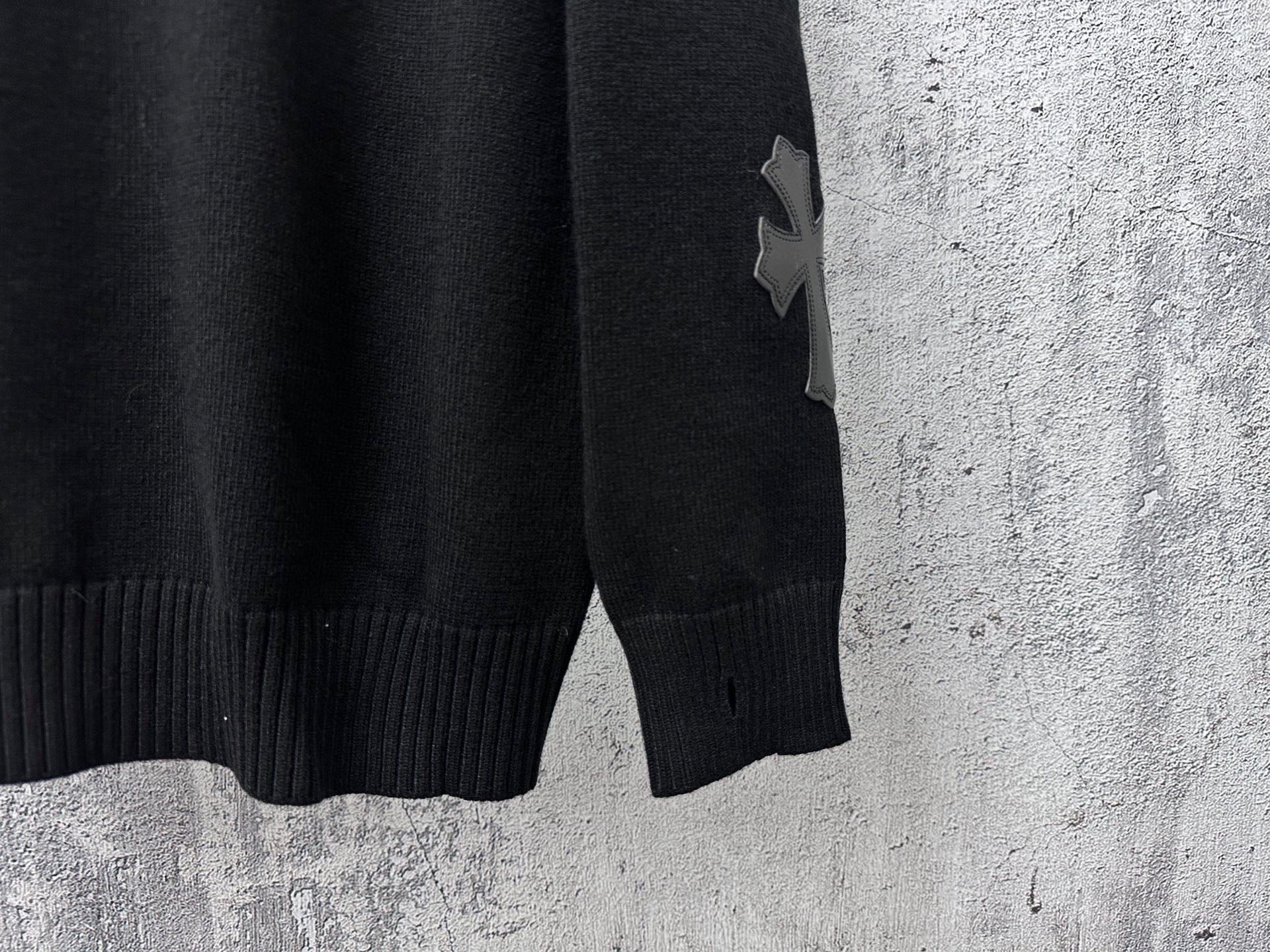Black knit sweater with ribbed hem and star applique on sleeve
